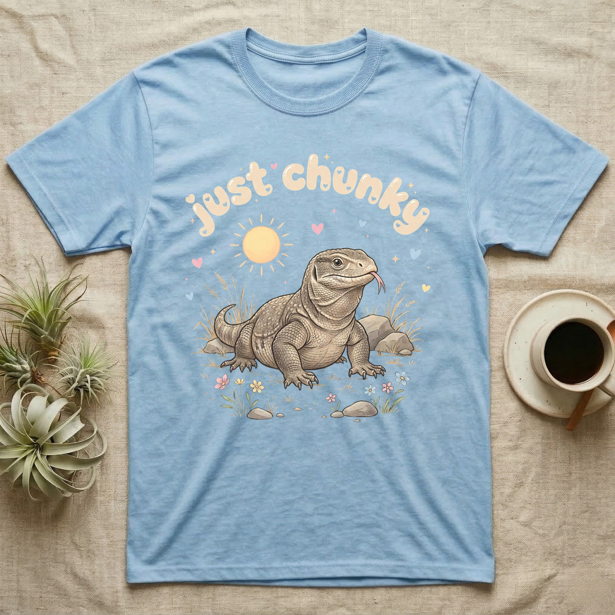 Savannah Monitor Softie T-Shirt in Light Blue — Plump savannah monitor lizard with flicking tongue under pastel bubble text "just chunky" and hearts.