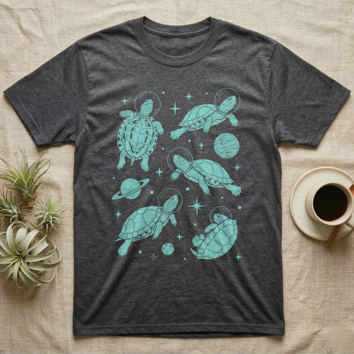 Red Eared Slider Cosmic T-Shirt in Dark Heather — Vintage screen-print illustration of red-eared slider turtles in astronaut helmets floating in space, cosmic teal monochromatic on dark background.