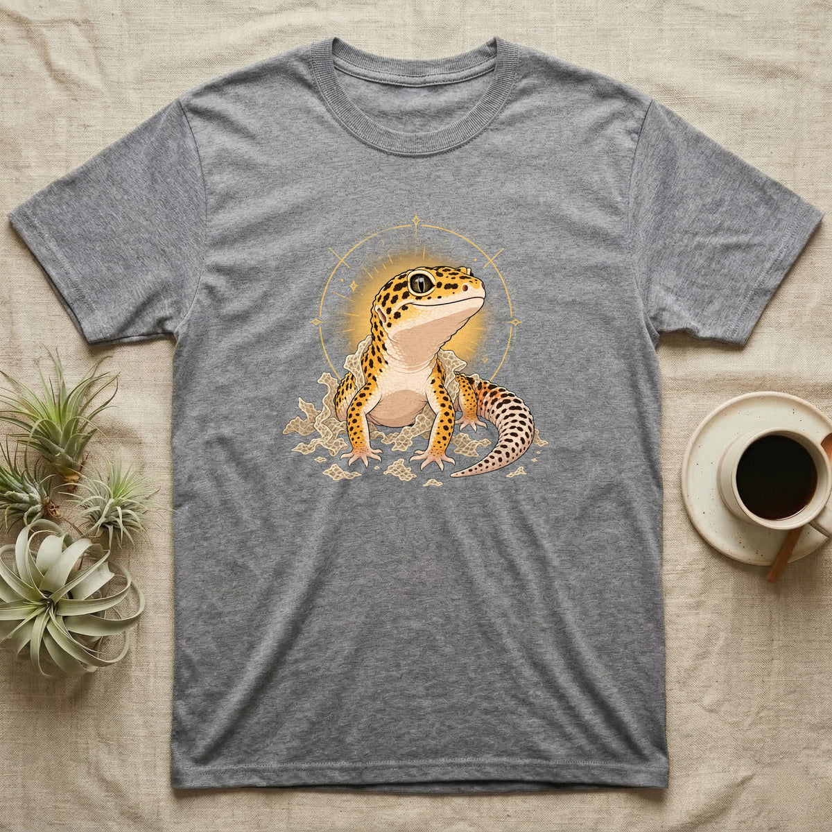 Leopard Gecko Shed T-Shirt in Sport Grey — Bold vector illustration of a leopard gecko emerging fresh from a shed, lit by a soft warm halo glow.