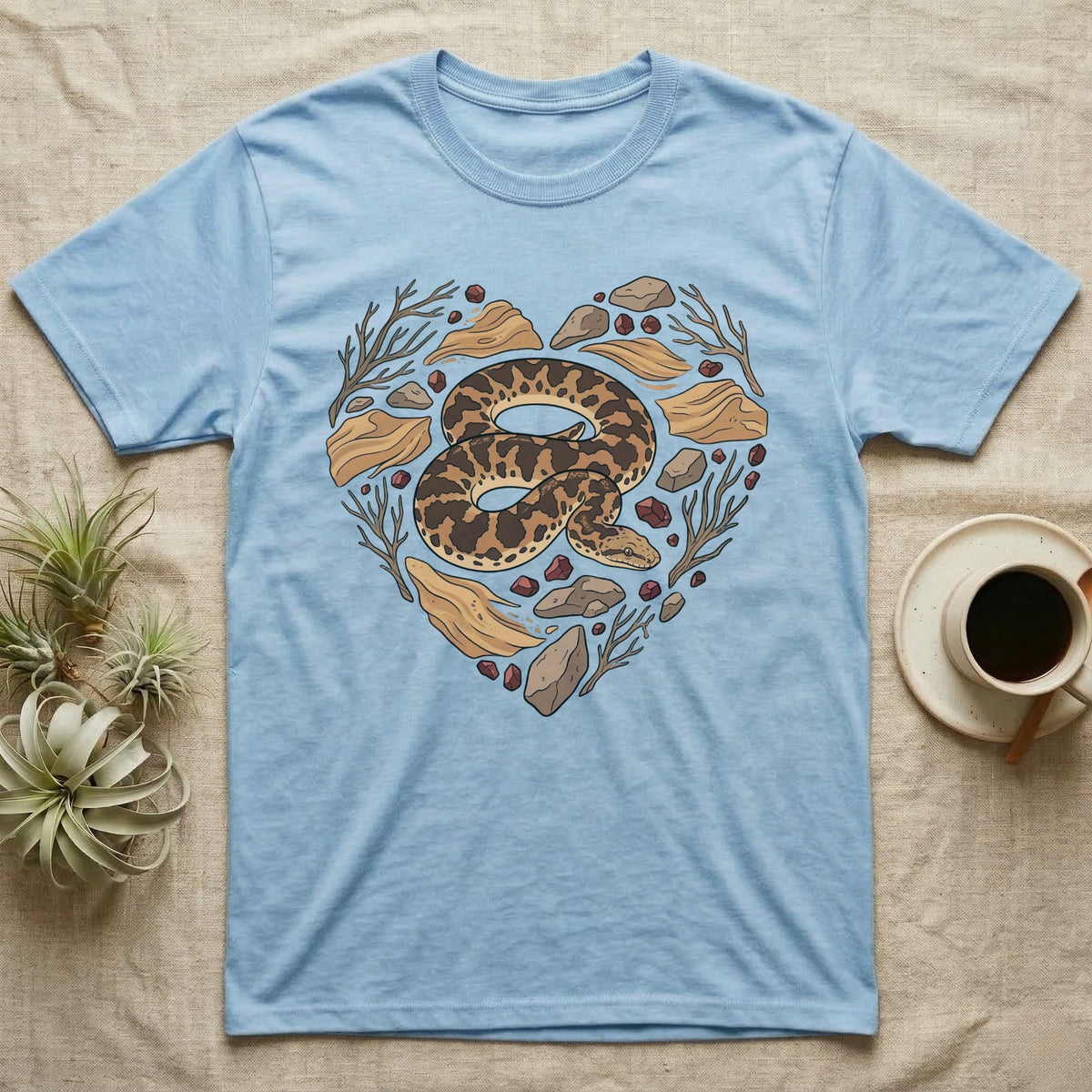Light blue t-shirt with a heart-shaped graphic of a snake and natural elements.