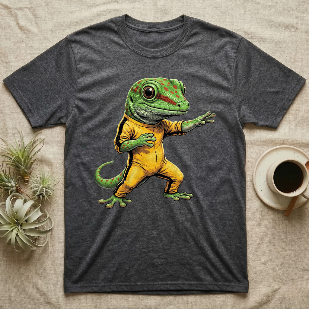 Anthropomorphic giant day gecko in a yellow-and-black martial-arts jumpsuit, low fighting stance, bold vintage-comic ink outlines and halftone shading, graphic-only design. — shown on a Dark Heather tee.
