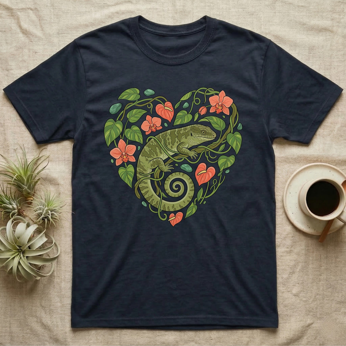 Dark t-shirt with a green lizard and coral flowers forming a heart.