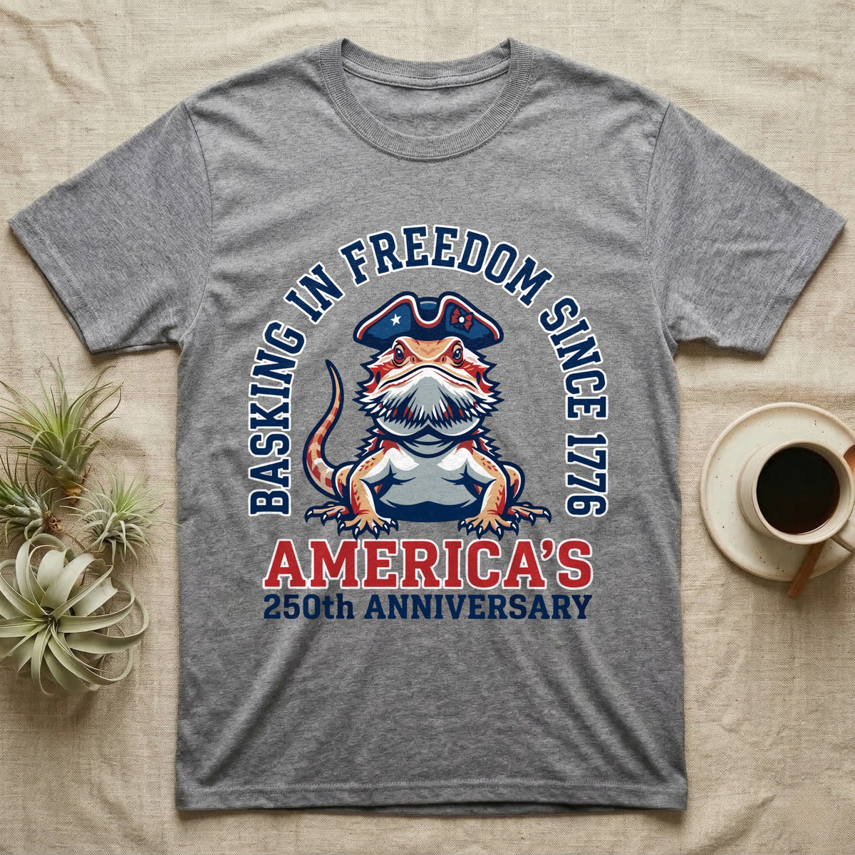 Bearded Dragon Basking T-Shirt in Sport Grey — Sports-logo bearded dragon in a tricorn hat under a collegiate arch reading Basking in Freedom Since 1776.