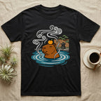 Black t-shirt with cartoon capybara wearing an orange slice relaxing in a hot spring.