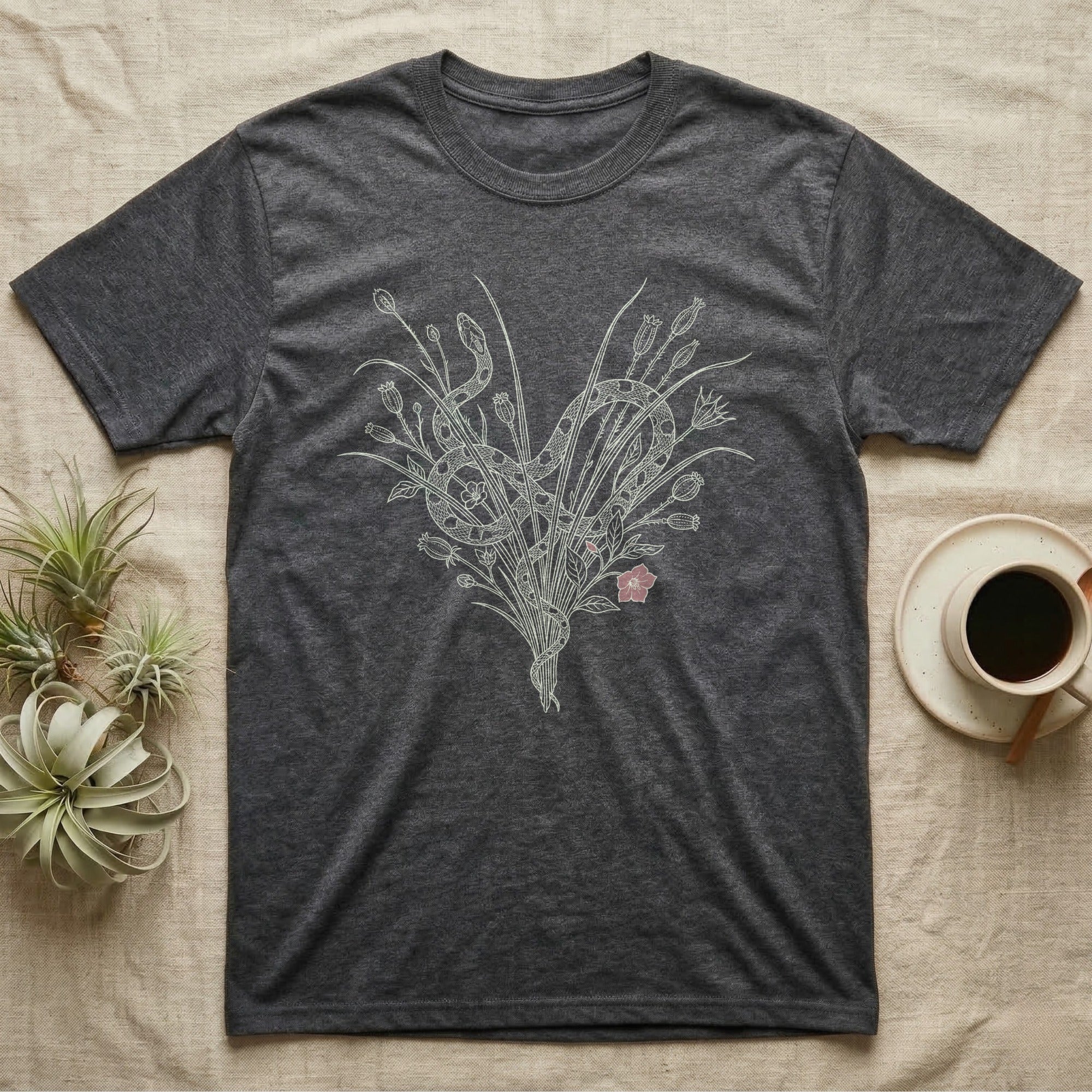 Corn Snake Gothic Botanical T-Shirt in Dark Heather — Corn snake coiling through fine pale hairline nightshade and seed-pod botanicals with one dusty rose bloom on grey