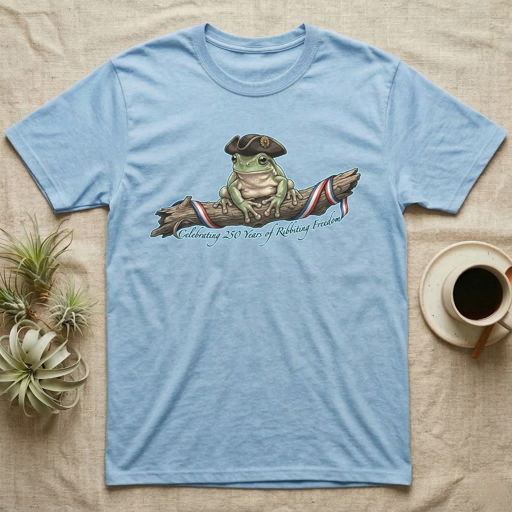 Tree Frog Freedom T-Shirt in Light Blue — Detailed green tree frog in a tricorn hat on a ribboned branch under script Celebrating 250 Years of Freedom.