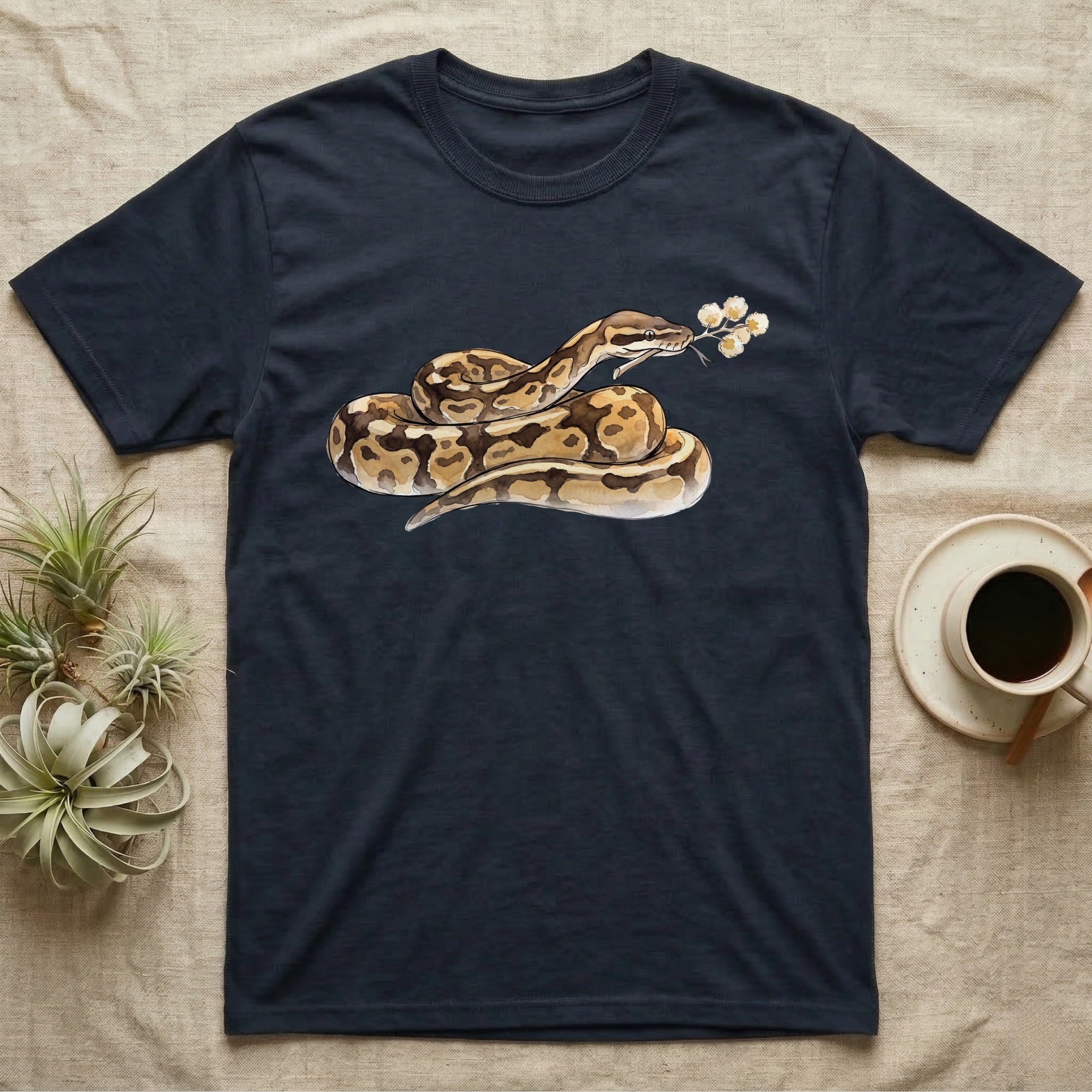 Ball Python Blossom T-Shirt in Navy — Watercolor illustration of a tan-and-brown ball python holding an acacia blossom sprig, on a dark grey t-shirt.