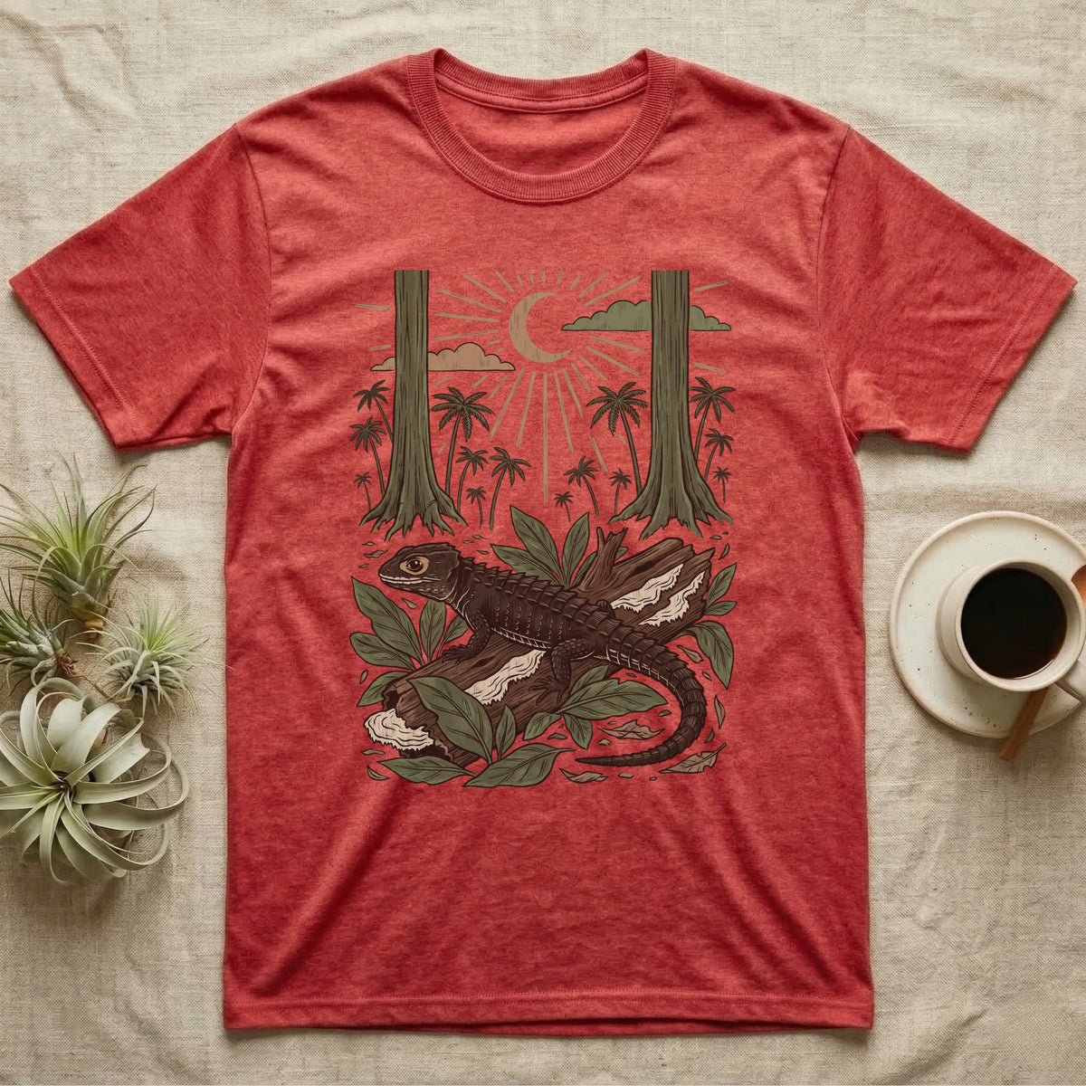 Crocodile Skink Home Range T-Shirt in Heather Red — Woodcut-style illustration of a red-eyed crocodile skink crouched on a rainforest log among broad leaves and palms, no on-shirt text.