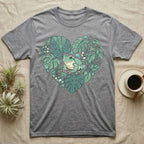 Gray t-shirt with a frog surrounded by green monstera leaves in a heart shape.