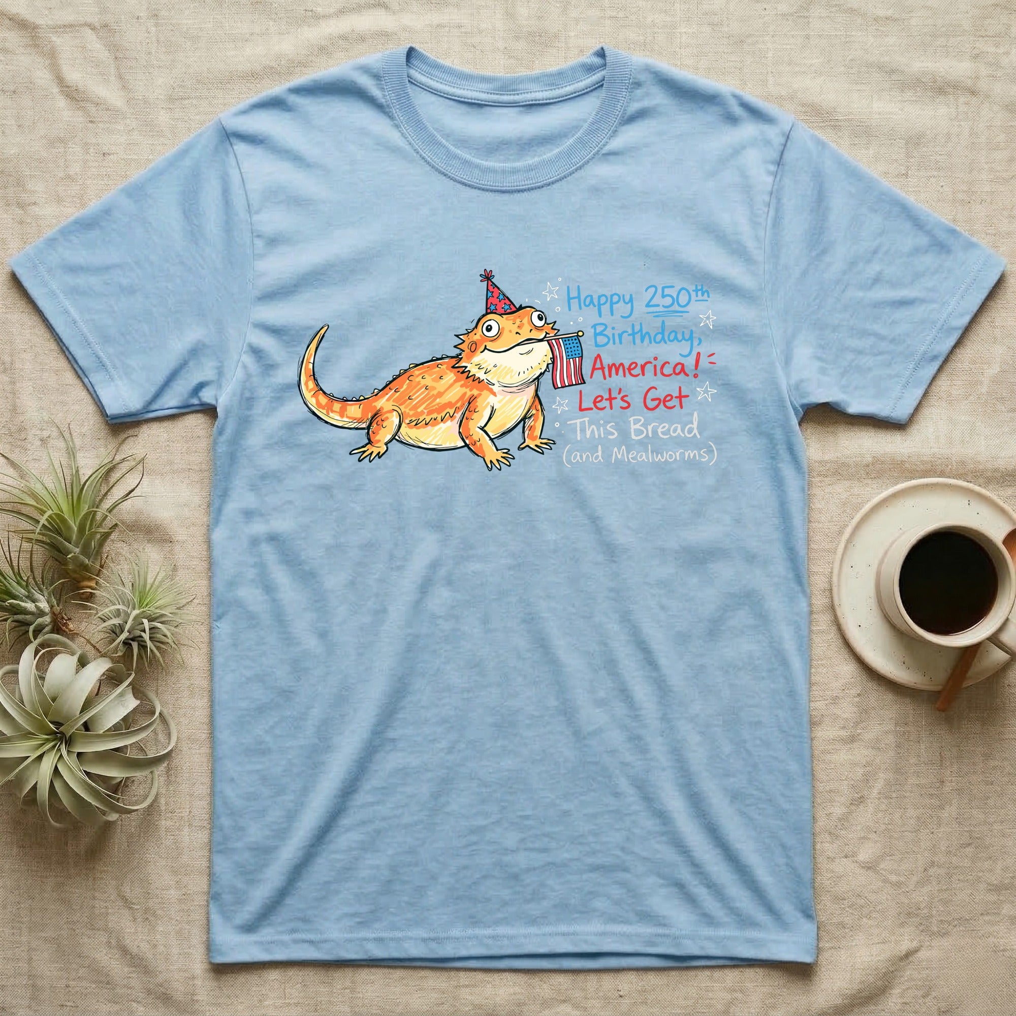 Bearded Dragon Birthday T-Shirt in Light Blue — Sketch-style bearded dragon in a party hat holding a flag with handwritten text Happy 250th Birthday, America.