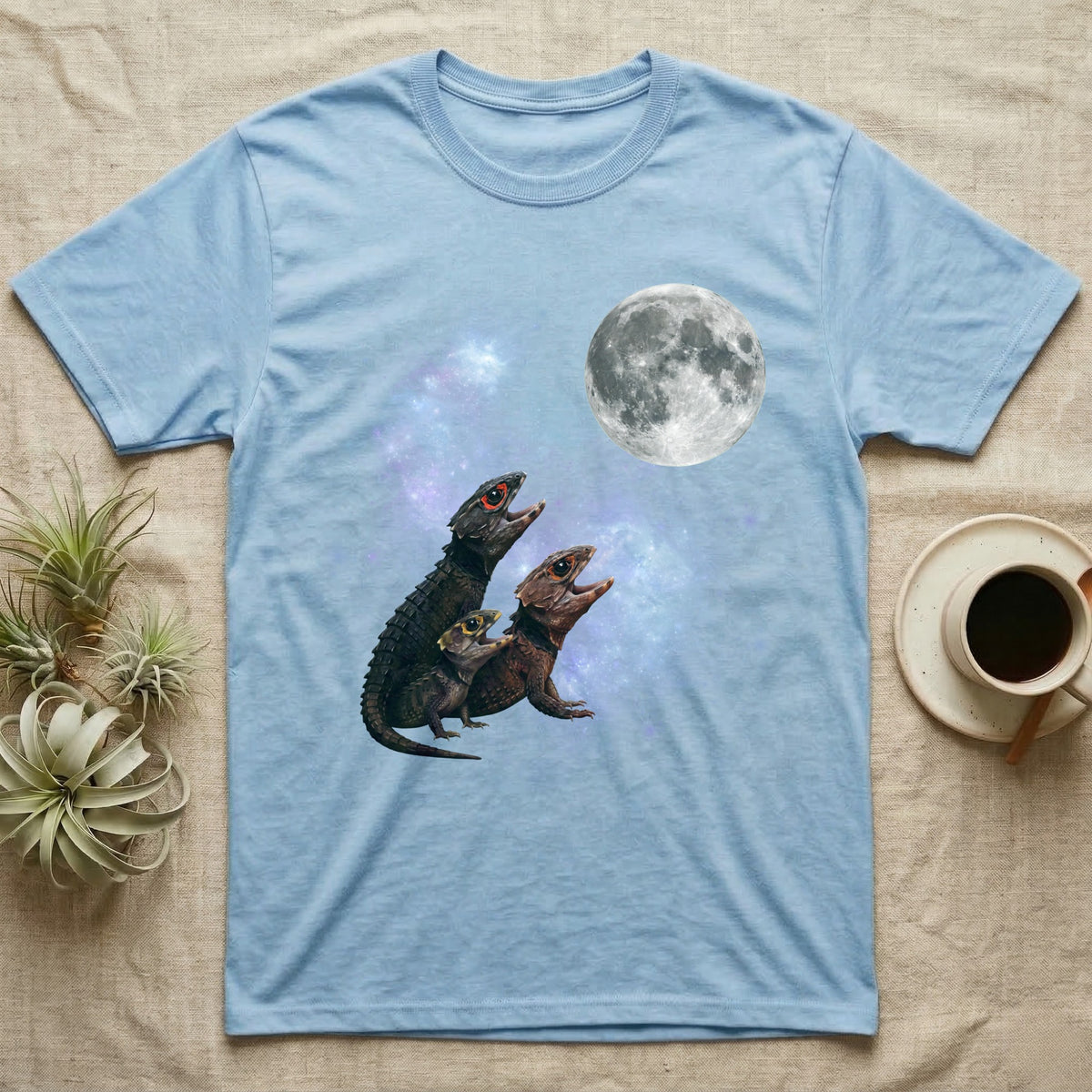 Red-Eyed Crocodile Skink Moon Howl T-Shirt in Light Blue — Three Red-Eyed Crocodile Skink colour morphs howling at a full moon over a nebula on a dark grey t-shirt.