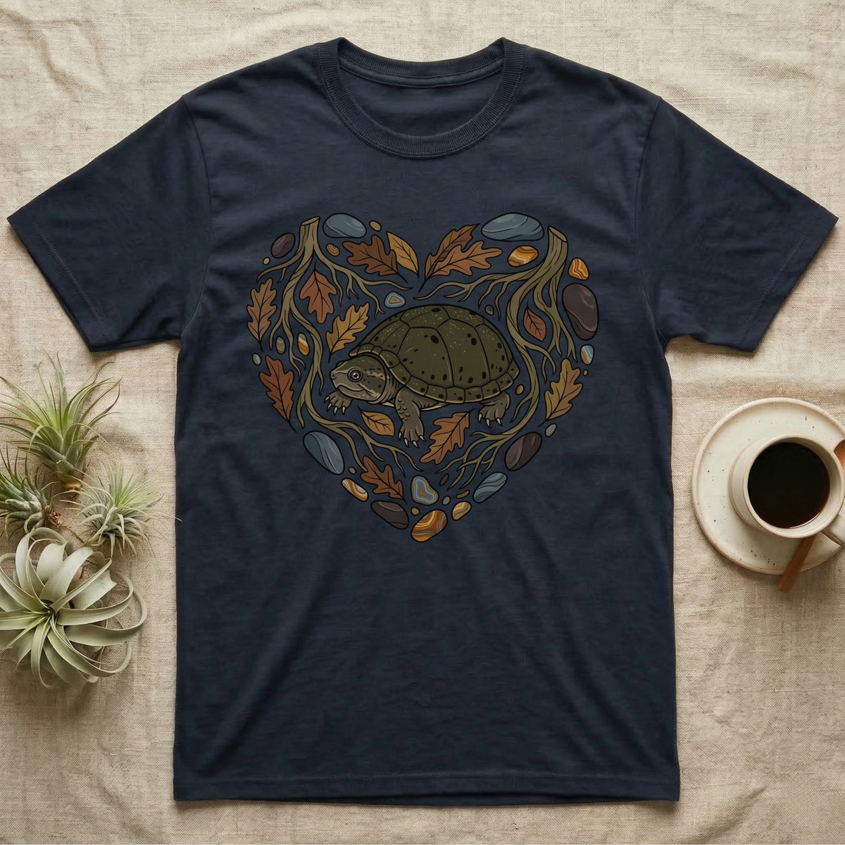Navy t-shirt with a heart-shaped design of a turtle, leaves, and rocks.