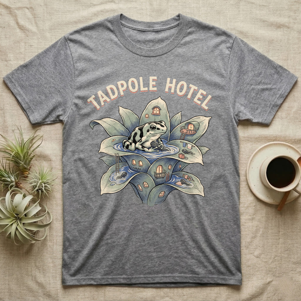 Tadpole Hotel Frog T-Shirt in Sport Grey — Whimsical naturalist illustration of a dart frog tucking tadpoles into a bromeliad Tadpole Hotel with hand-lettered marquee text.