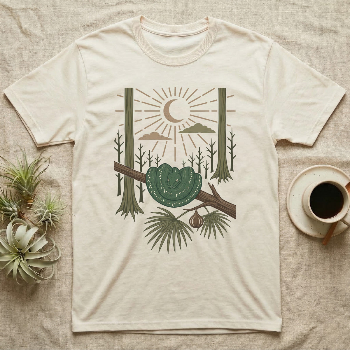 Green Tree Python Home Range T-Shirt in Natural — Woodcut-style illustration of a green tree python coiled in a saddle over a branch with palms and tall trunks behind, no on-shirt text.