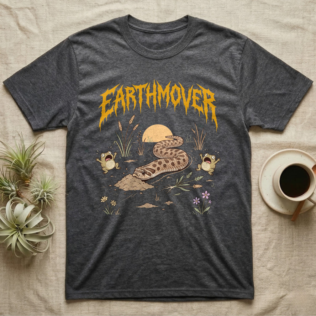 Western Hognose Earthmover T-Shirt in Dark Heather — Western hognose snake bulldozing a mound of dirt as two frogs scream, under dripping EARTHMOVER lettering with a low sun and wildflowers.