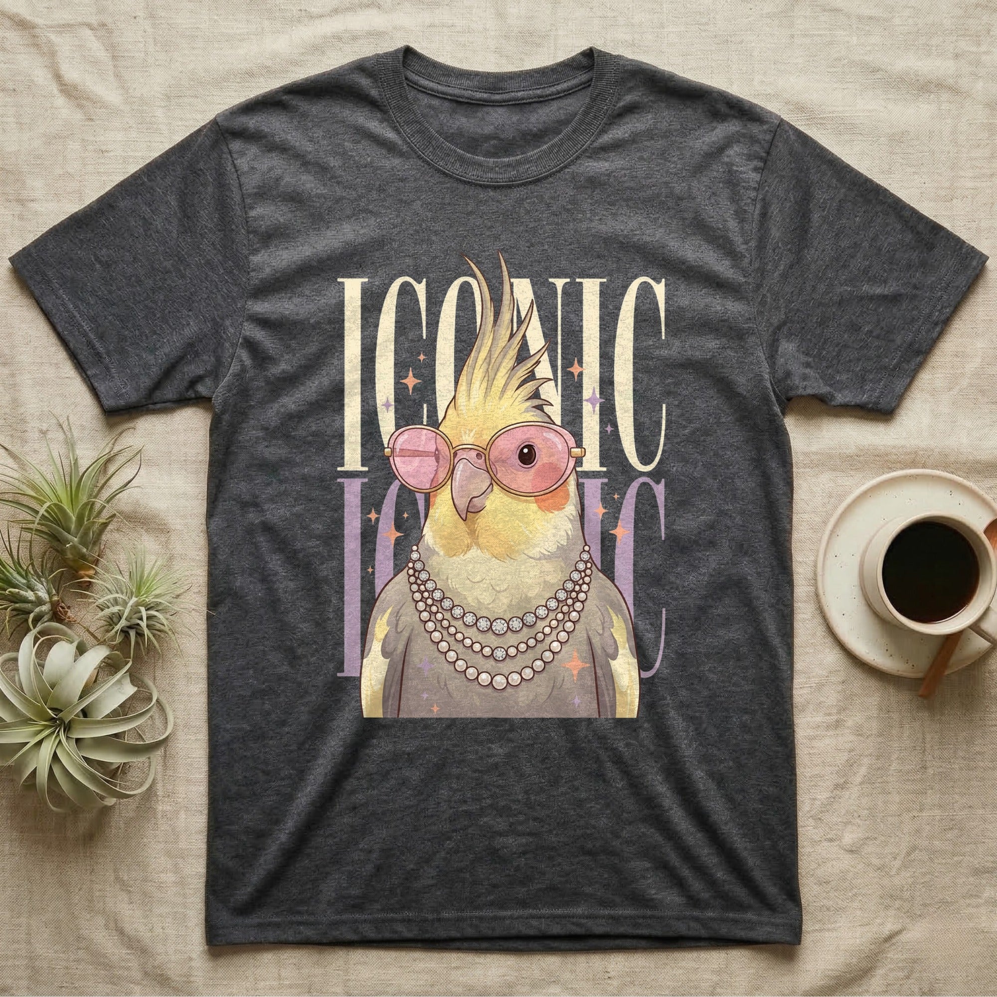 Dark t-shirt with "ICONIC" text and a cartoon cockatiel wearing glasses.