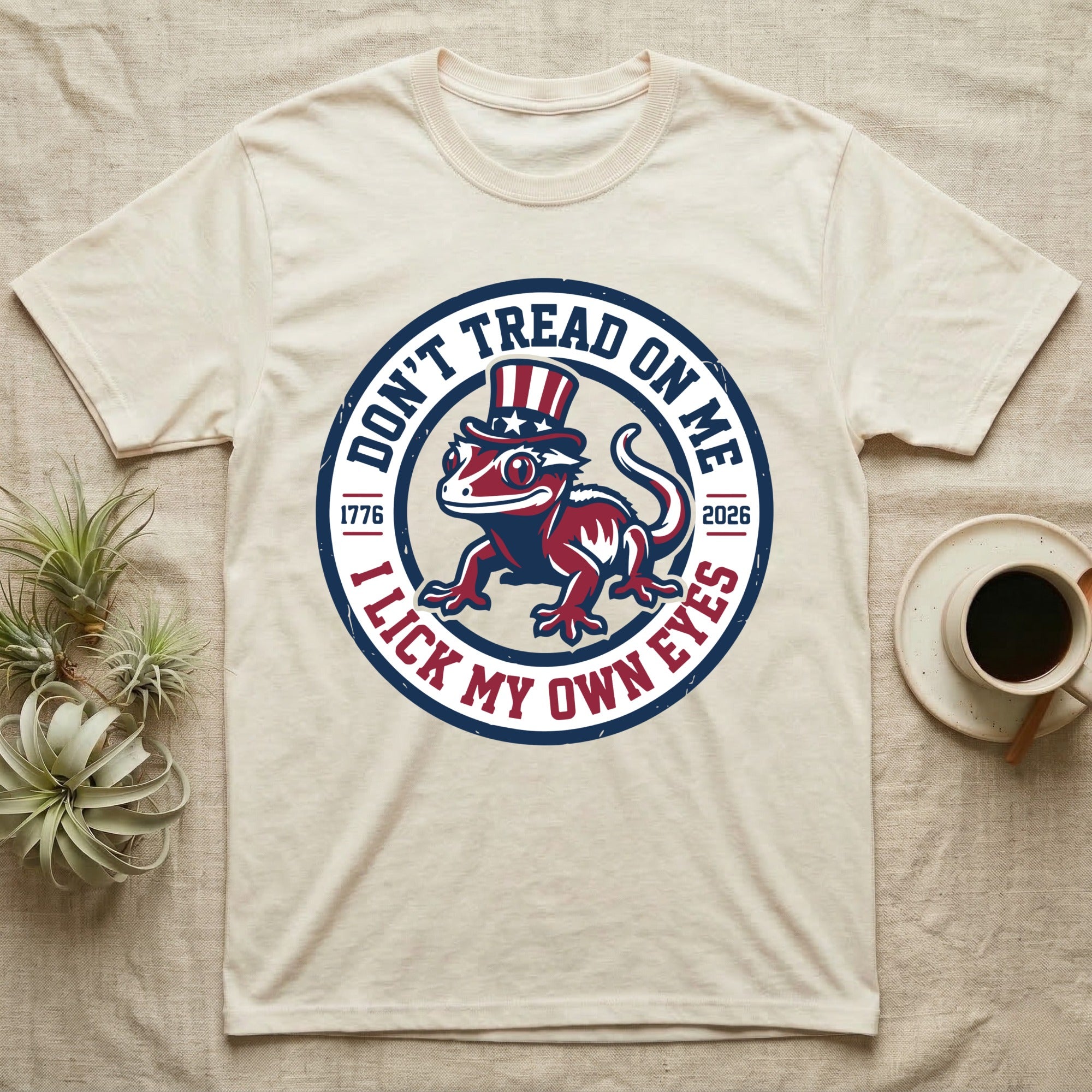 Crested Gecko 1776 T-Shirt in Natural — Distressed crest of a crested gecko in a top hat with text Don't Tread On Me and I Lick My Own Eyes.