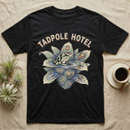 Tadpole Hotel Frog T-Shirt in Black — Whimsical naturalist illustration of a dart frog tucking tadpoles into a bromeliad Tadpole Hotel with hand-lettered marquee text.