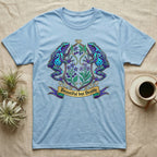 Light blue t-shirt with ornate frog and floral crest design.