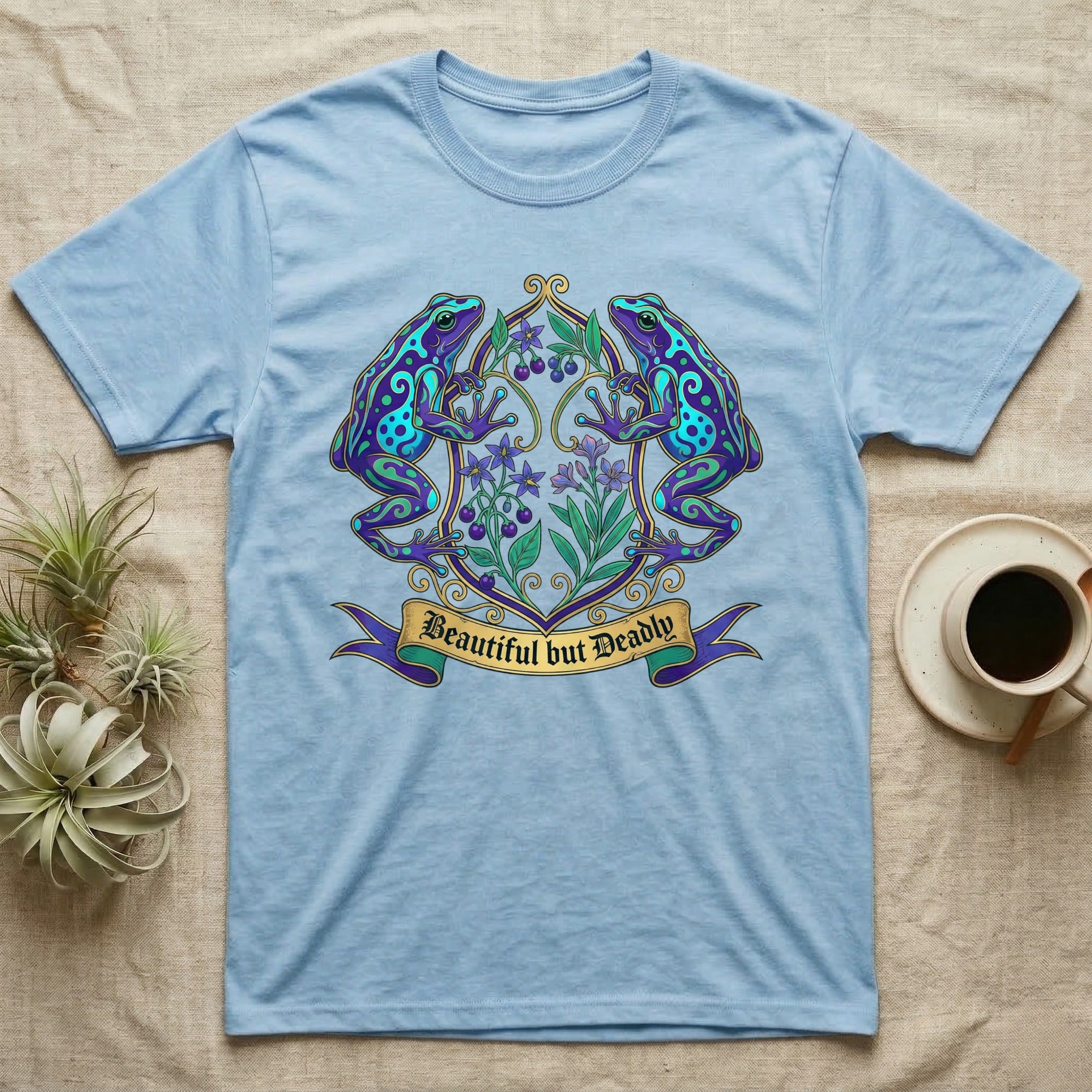 Light blue t-shirt with ornate frog and floral crest design.