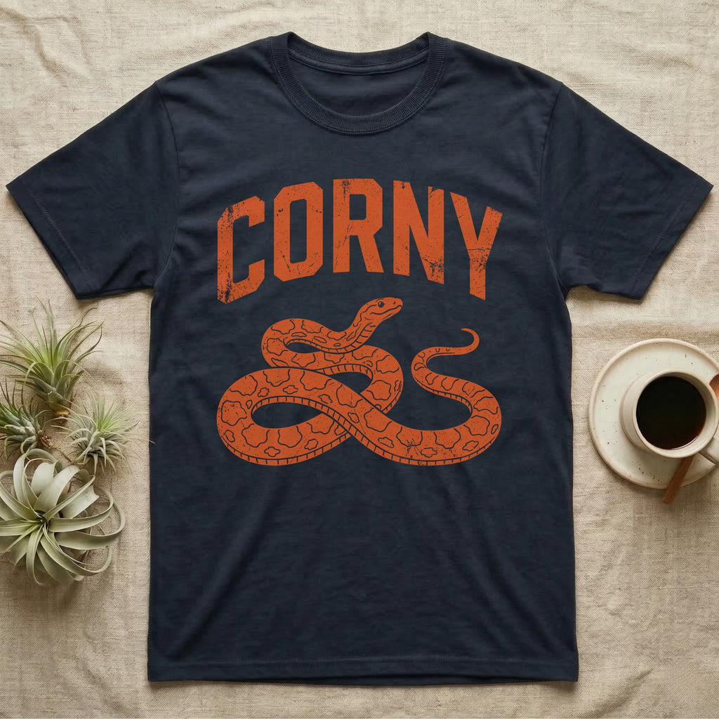 Corn Snake Corny T-Shirt in Navy — Worn orange one-ink print of a corn snake lying in loose coils, head raised, under the arched word Corny