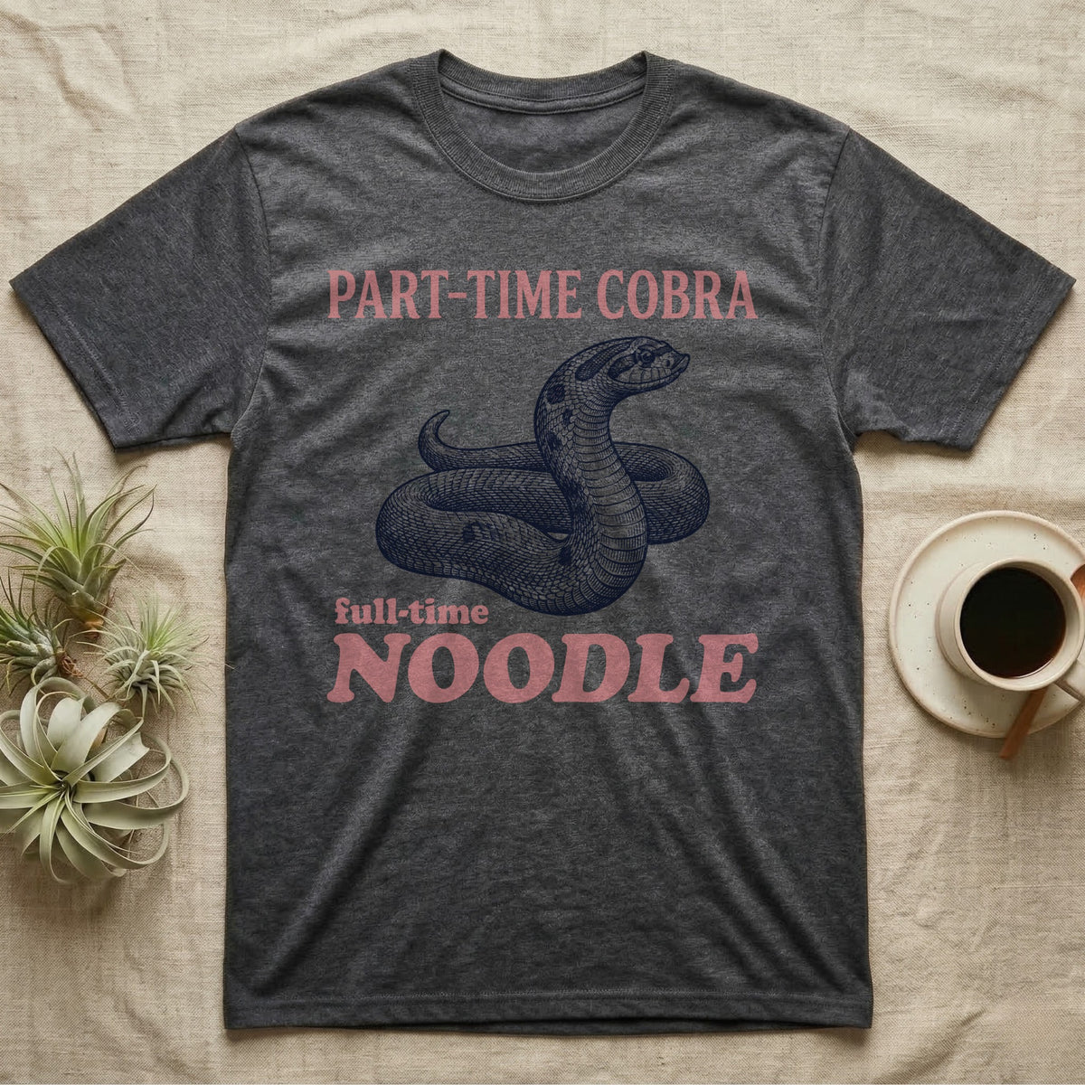 Hognose Snake Noodle T-Shirt in Dark Heather — Navy engraving of a coiled western hognose snake bluffing with a flattened neck between the words PART-TIME COBRA and full-time NOODLE in rose