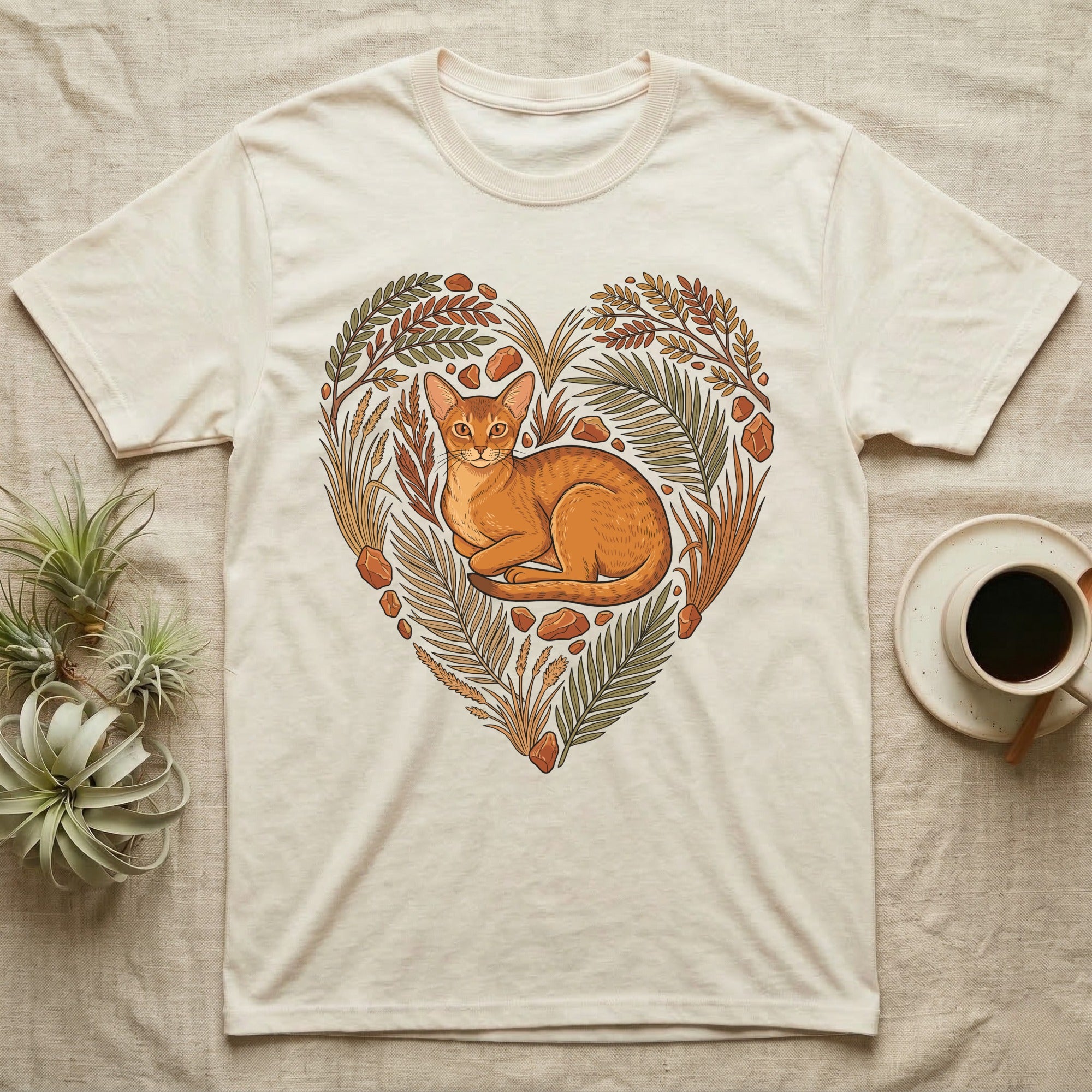 Cream t-shirt with a heart-shaped floral design featuring a resting cat.