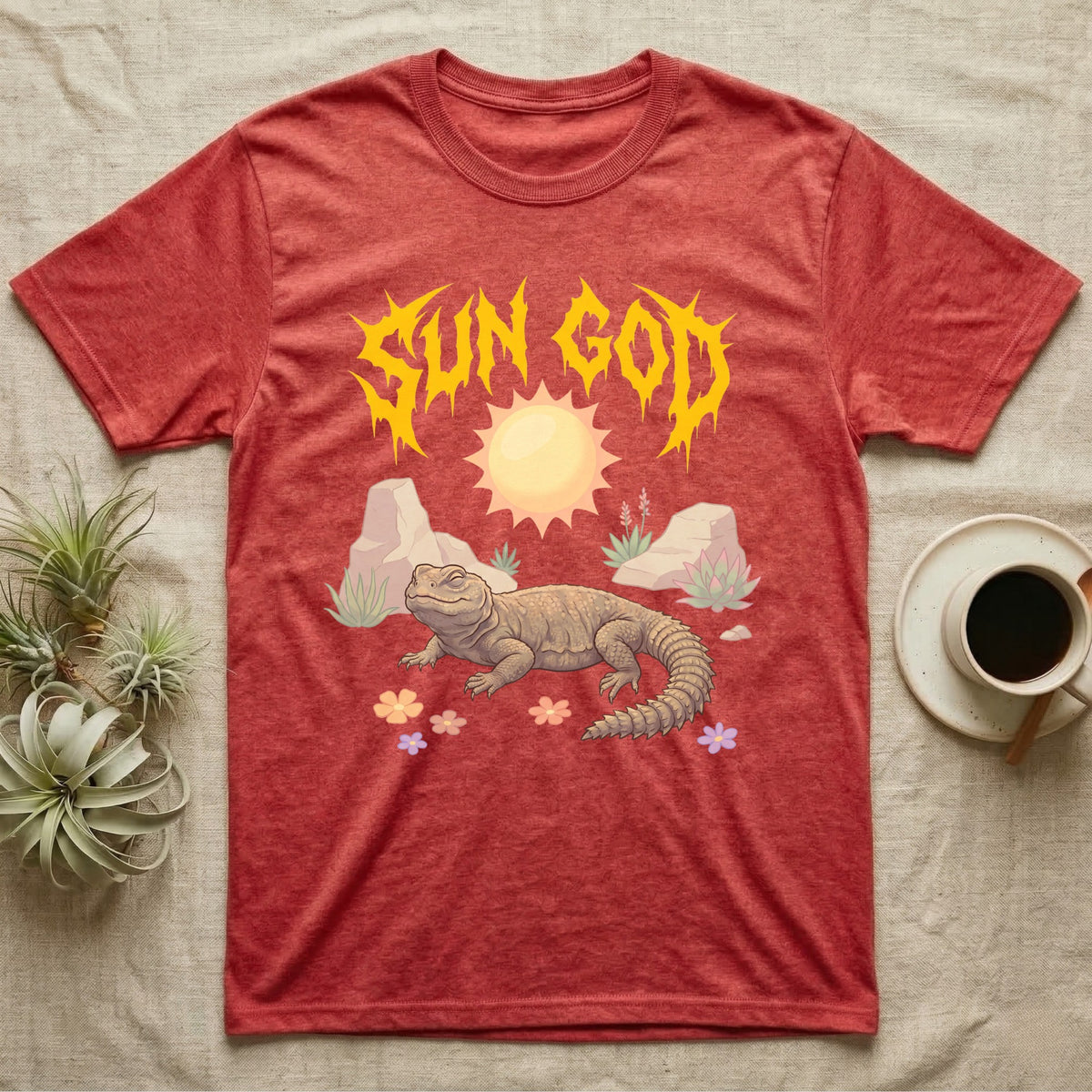 Moroccan Uromastyx Feral T-Shirt in Heather Red — Moroccan uromastyx basking under a big sun with a jagged solar-gold metal "SUN GOD" wordmark and pastel desert scene.
