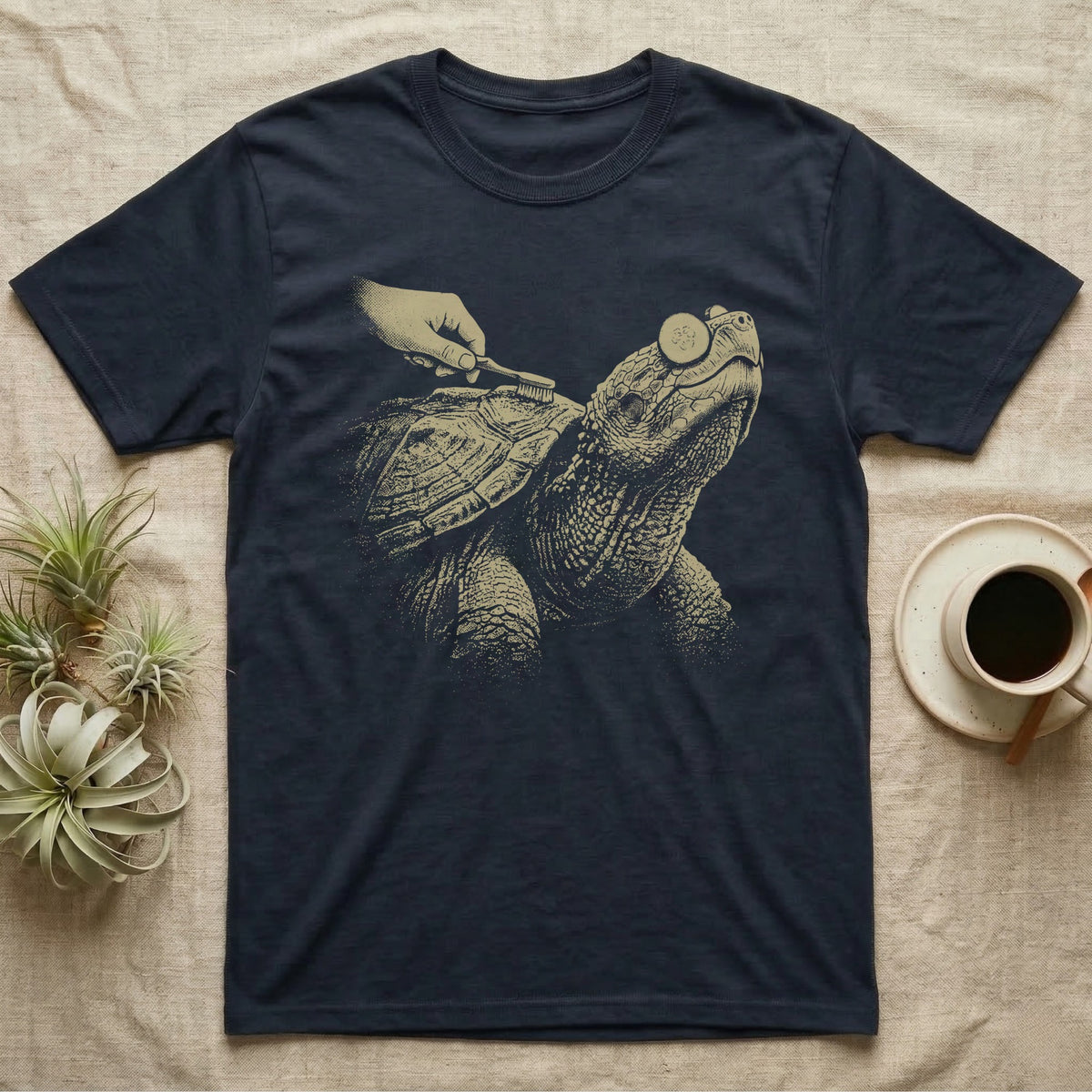 Snapping Turtle Spa T-Shirt in Navy — Single-ink snapping turtle with cucumber slices on its eyes, chin up, while a hand scrubs its shell with a toothbrush.