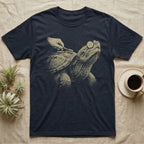 Snapping Turtle Spa T-Shirt in Navy — Single-ink snapping turtle with cucumber slices on its eyes, chin up, while a hand scrubs its shell with a toothbrush.