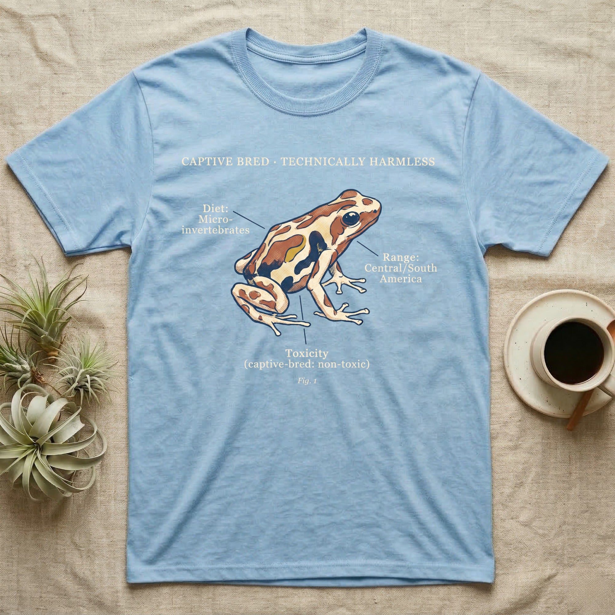 Captive Bred Dart Frog T-Shirt in Light Blue — Retro science-plate illustration of a labeled dart frog with field-guide callouts and a captive-bred non-toxic note.