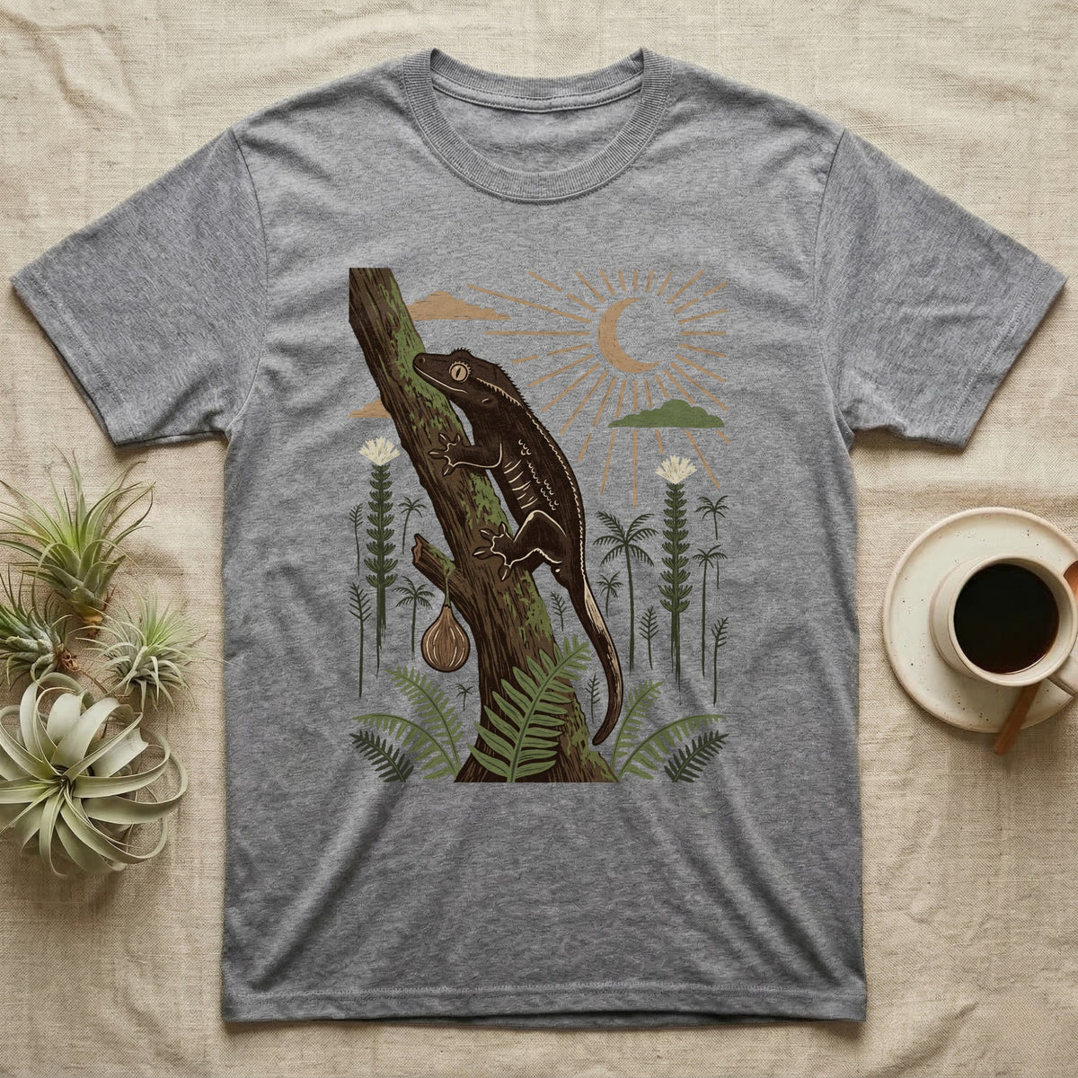 Crested Gecko Home Range T-Shirt in Sport Grey — Woodcut-style illustration of a crested gecko clinging head-up to a mossy rainforest trunk among tree ferns, no on-shirt text.