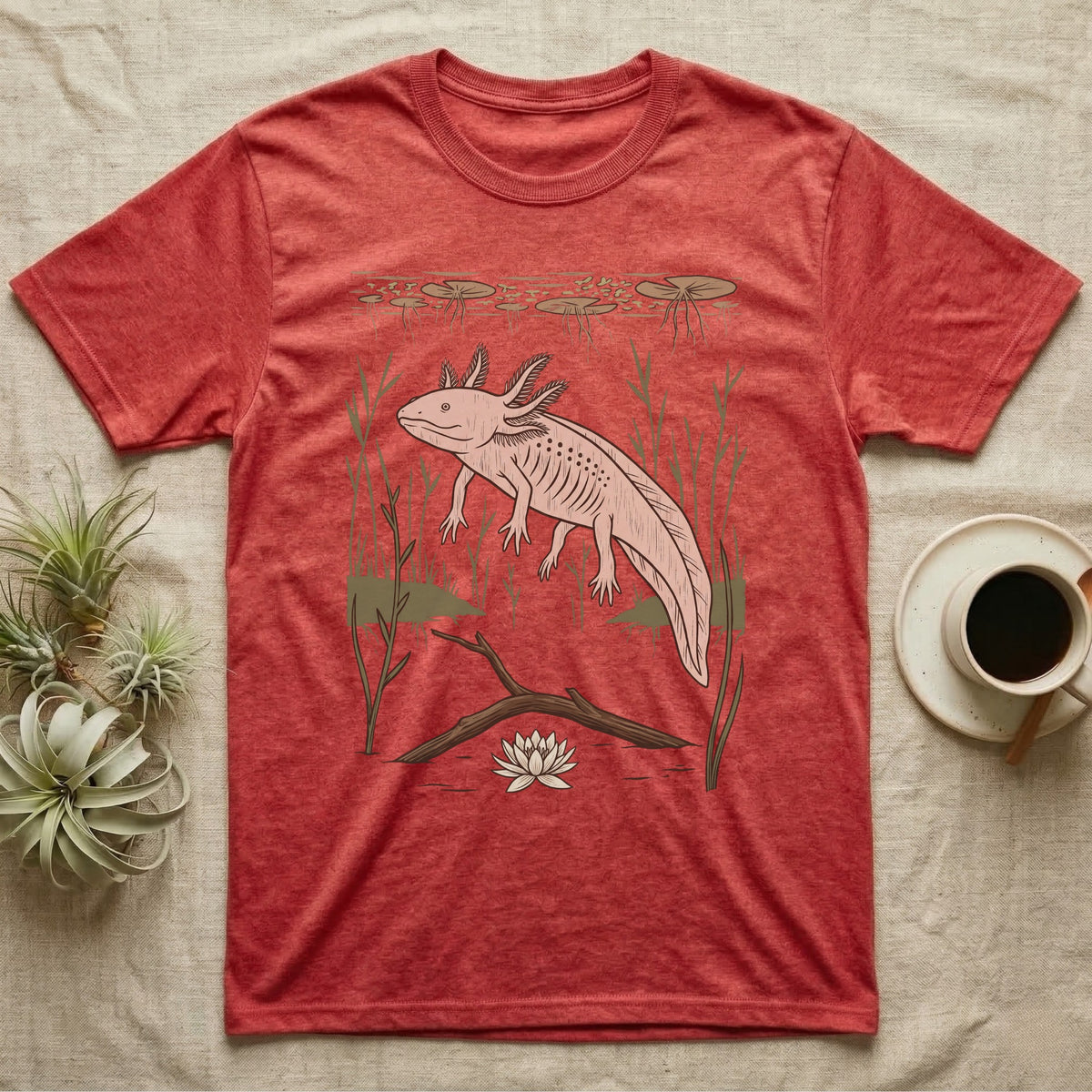Axolotl Home Range T-Shirt in Heather Red — Woodcut-style illustration of an axolotl drifting among reeds and lily pads in a Xochimilco canal, no on-shirt text.