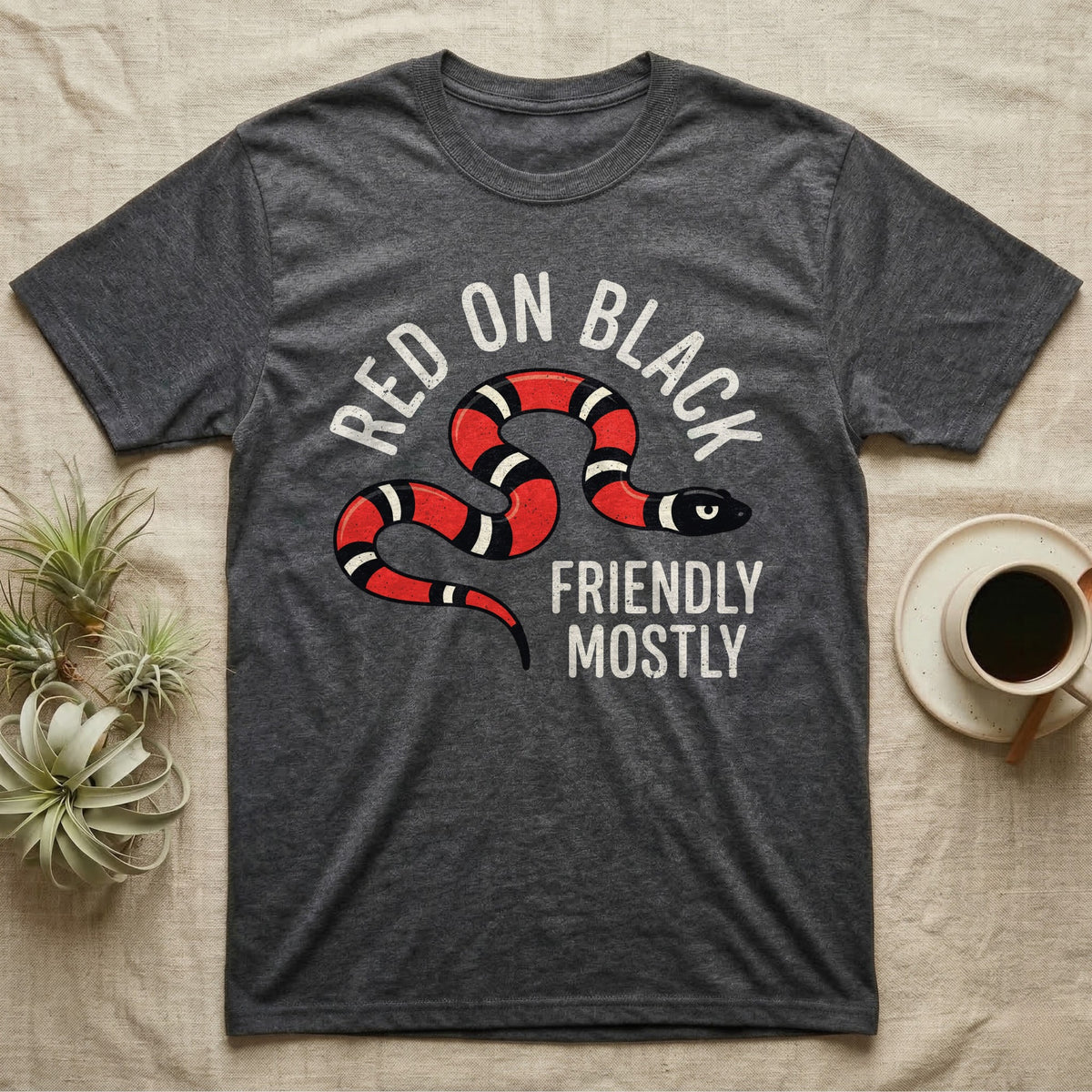 Milk Snake Friendly T-Shirt in Dark Heather — Worn screen-print of a red, black and cream banded milk snake under the cream words Red On Black, Friendly, Mostly