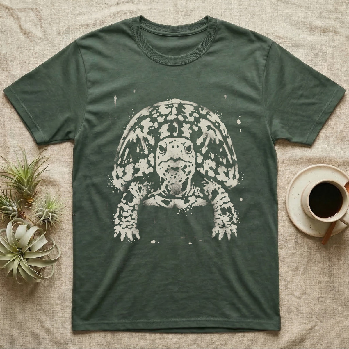 Eastern Box Turtle Bleach T-Shirt in Military Green — Eastern box turtle facing forward, its domed shell and legs emerging from pale bleach spatter on a black ground.