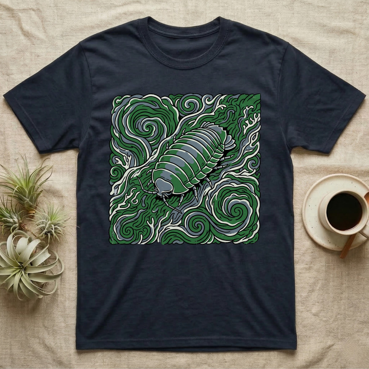 Dark t-shirt with green pill bug illustration on swirling abstract background.
