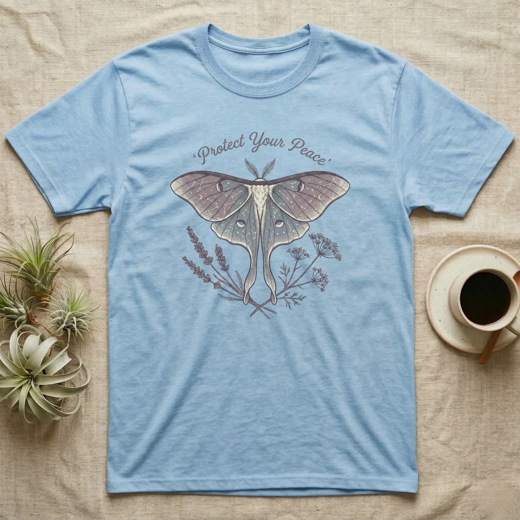 Light blue t-shirt with a luna moth and floral design, "Protect Your Peace" text.