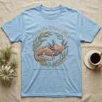 Axolotl Save Weird Fish T-Shirt in Light Blue — Botanical axolotl with teal gill plumes inside a water-plant wreath; script type "Save the Weird Fish" arched above.