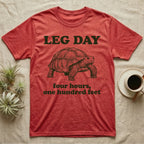 Sulcata Tortoise Leg Day T-Shirt in Heather Red — Engraved sulcata tortoise in deep green ink beneath the words LEG DAY, with four hours, one hundred feet below.