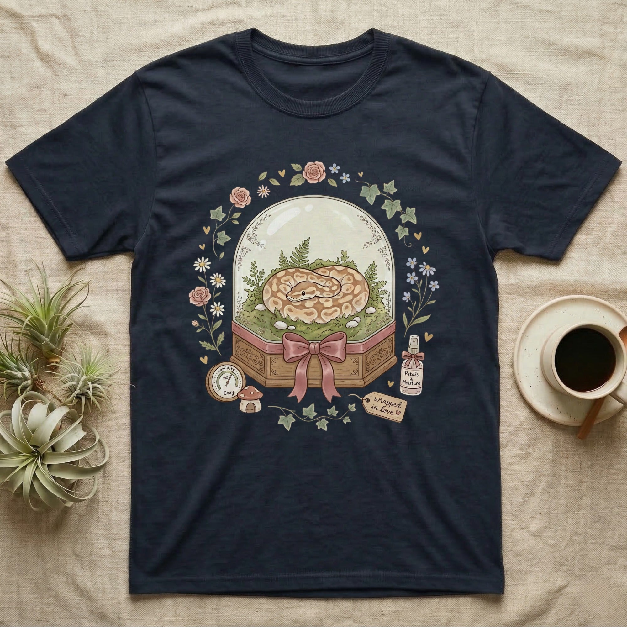 Navy t-shirt with a glass dome containing a snake, flowers, and mushrooms.