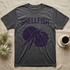 Hermit Crab Shellfish T-Shirt in Dark Heather — Worn purple one-ink print of a hermit crab hugging a big spare shell to its chest under the word Shellfish