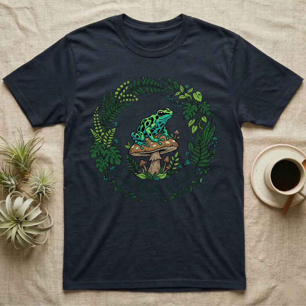 Dark t-shirt with a frog on a mushroom, surrounded by a wreath of leaves.