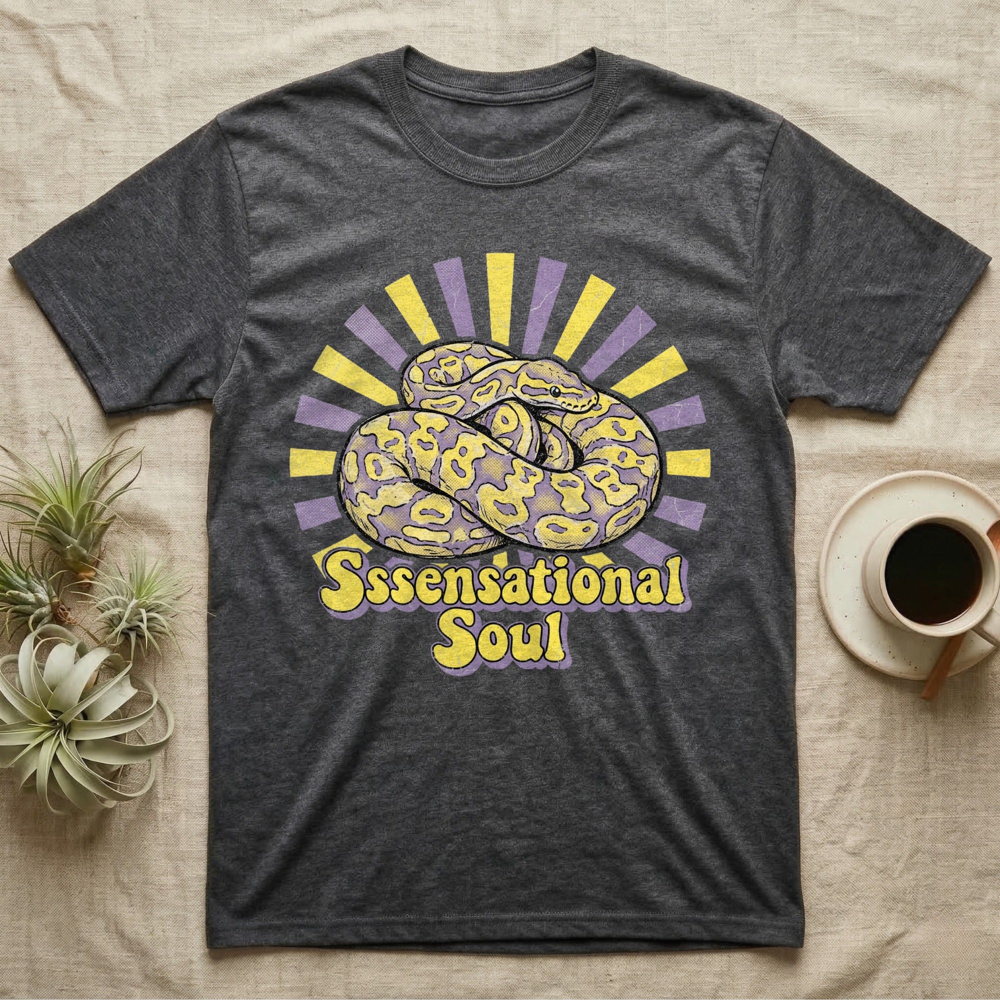 Dark grey t-shirt with yellow and purple sunburst graphic and text.