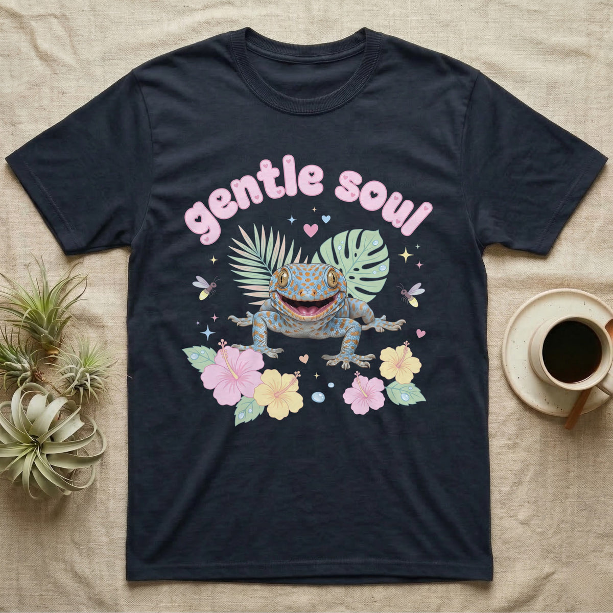Tokay Gecko Baby T-Shirt in Navy — Blue-and-orange spotted tokay gecko among pastel leaves and hibiscus under puffy pink bubble text "gentle soul".