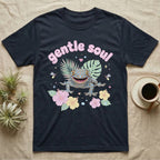 Tokay Gecko Baby T-Shirt in Navy — Blue-and-orange spotted tokay gecko among pastel leaves and hibiscus under puffy pink bubble text "gentle soul".