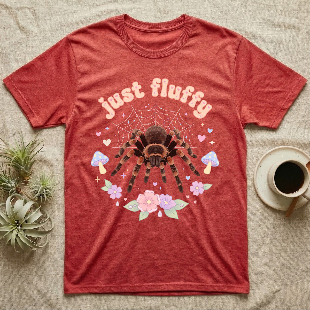Mexican Redknee Tarantula Baby T-Shirt in Heather Red — Fuzzy Mexican redknee tarantula on a pastel web with blossoms under puffy peach bubble text "just fluffy".