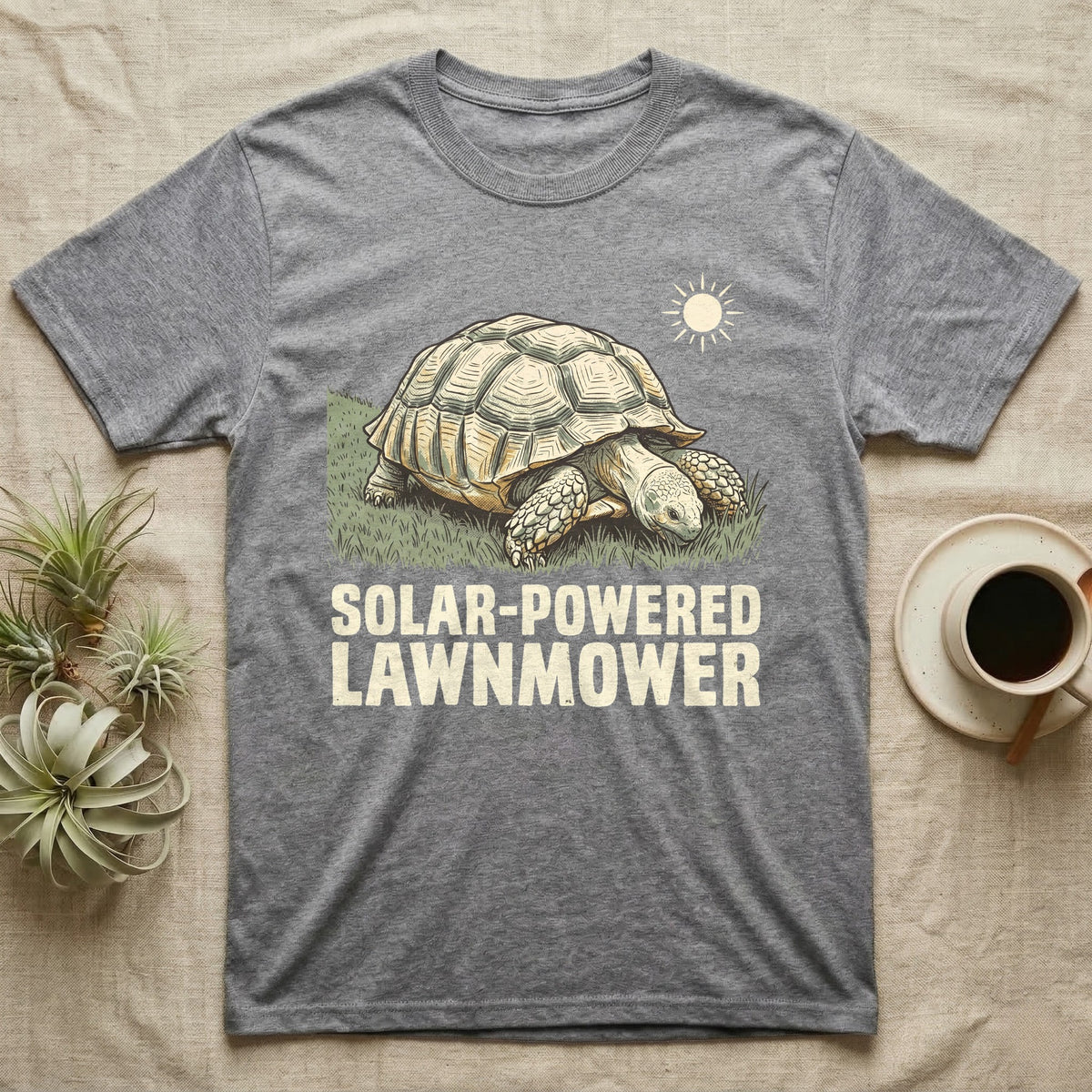 Solar Powered Lawnmower T-Shirt in Sport Grey — Retro-illustration of a sulcata tortoise grazing a lawn stripe under a sun motif with a Solar-Powered Lawnmower caption.