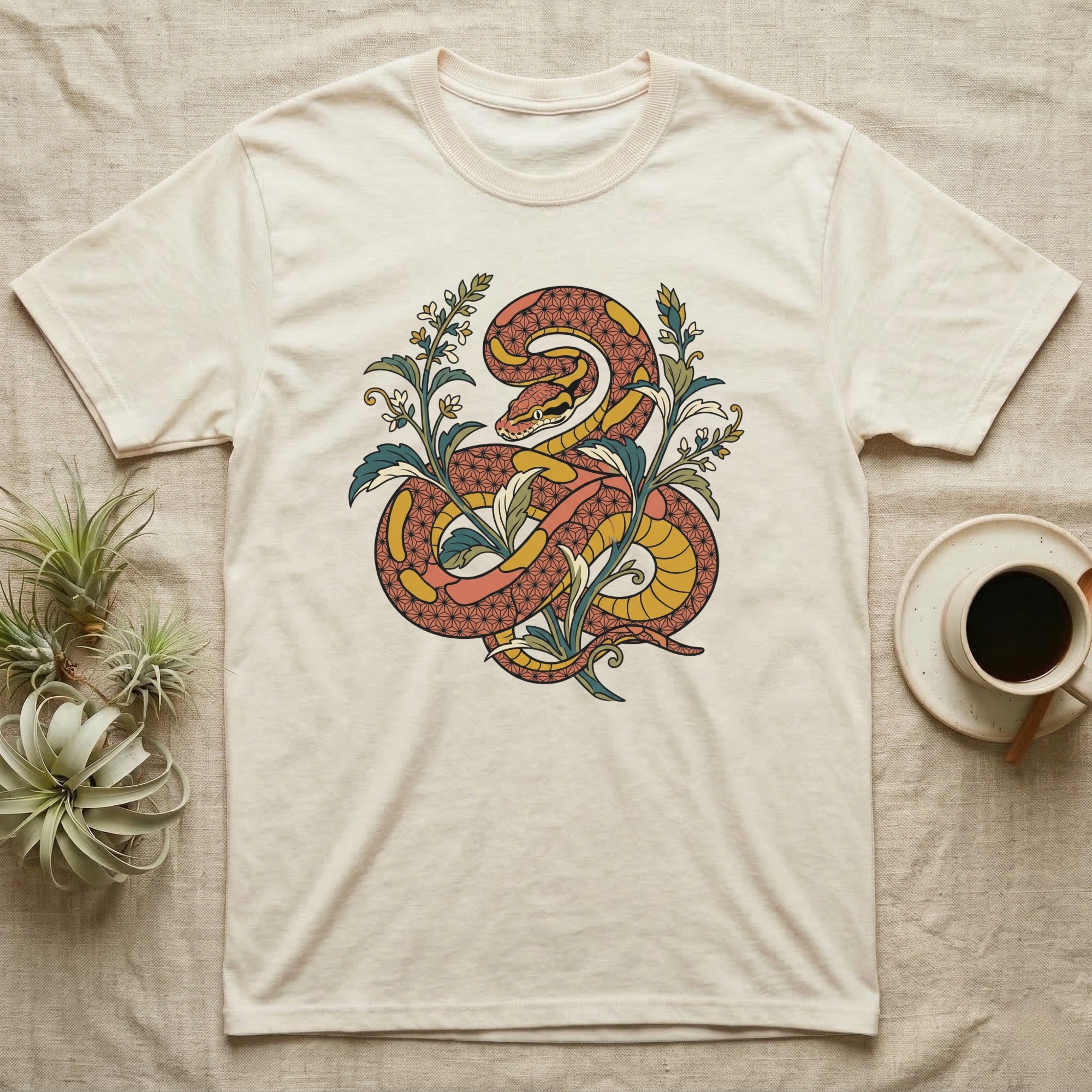 Cream t-shirt with a coiled snake and floral design.