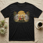 Sulcata Hibiscus Thief T-Shirt in Black — Painted 90s wildlife art of a sulcata tortoise walking through a broken picket fence with a red hibiscus flower in its beak
