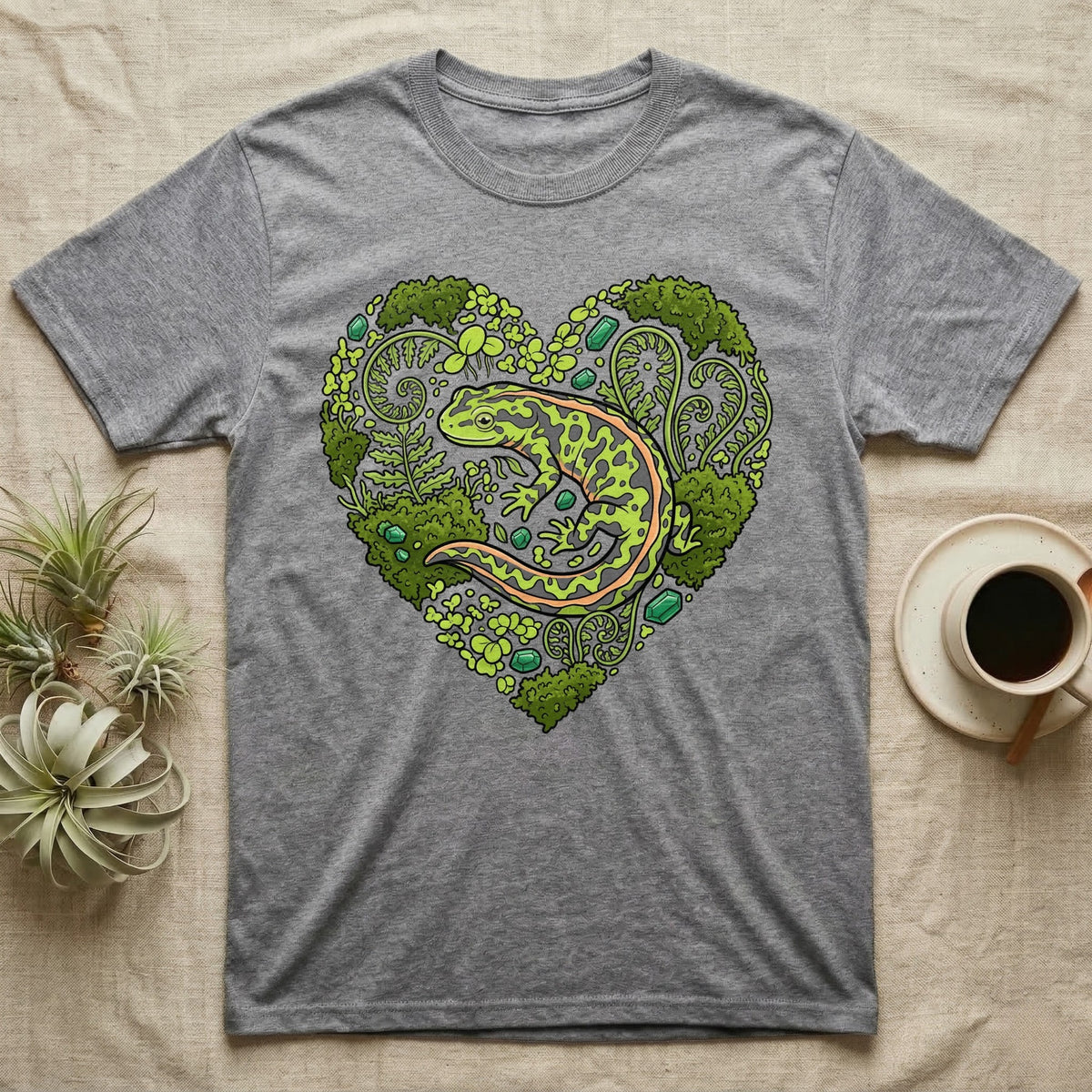 Grey t-shirt with a green salamander design surrounded by heart-shaped leaves.